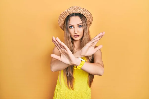 Young Blonde Girl Wearing Summer Hat Rejection Expression Crossing Arms — Stockfoto