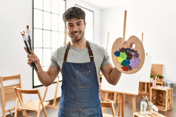 Mladý Hispánský Umělec Muž Usměvavý Šťastný Drží Štětce Paletu Uměleckém — Stock fotografie