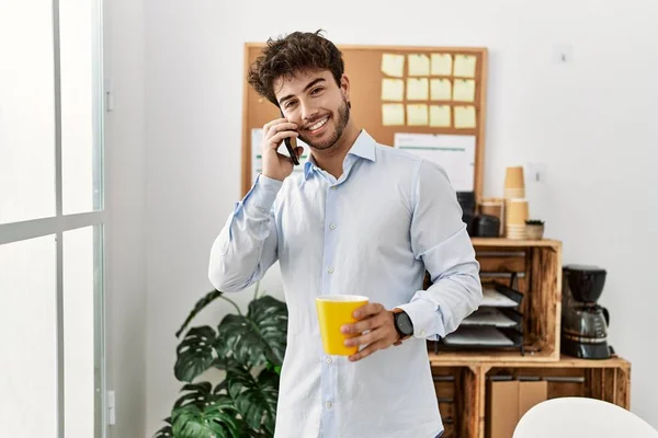 Young Hispanic Businessman Drinking Coffee Talking Smartphone Office — Foto Stock