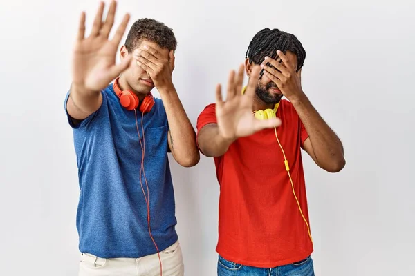 Jonge Spaanse Broeders Die Een Geïsoleerde Achtergrond Staan Een Koptelefoon — Stockfoto