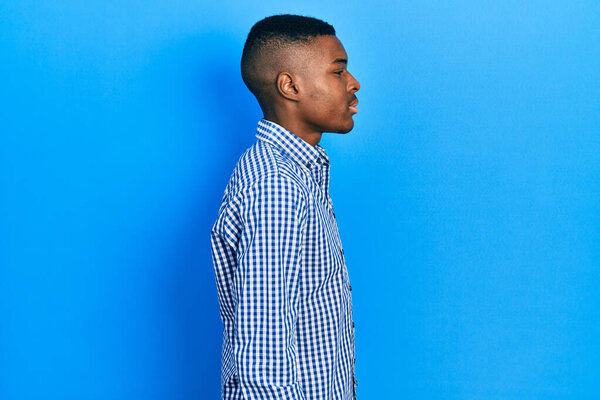 Young african american man wearing casual clothes looking to side, relax profile pose with natural face with confident smile. 