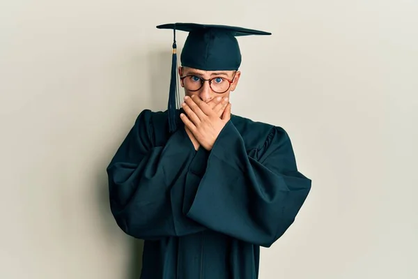 Young Caucasian Man Wearing Graduation Cap Ceremony Robe Shocked Covering — стоковое фото