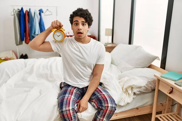 Junge Hispanische Mann Mit Wecker Sitzt Auf Dem Schlafzimmer Verängstigt — Stockfoto
