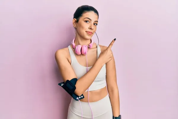 Ung Latinamerikansk Kvinna Klädd Gympakläder Och Med Hörlurar Pekande Med — Stockfoto