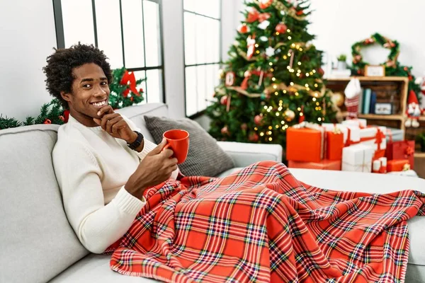 Jovem Afro Americano Sentado Sofá Bebendo Café Junto Árvore Natal — Fotografia de Stock