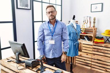 Orta yaşlı bir adam butikte yönetici olarak çalışıyor. Uykulu ve yorgun görünüyor. Yorgun ve akşamdan kalma, tembel gözlü.. 