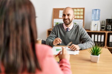 Ofiste çalışırken gülümseyen iki İspanyol iş adamı..