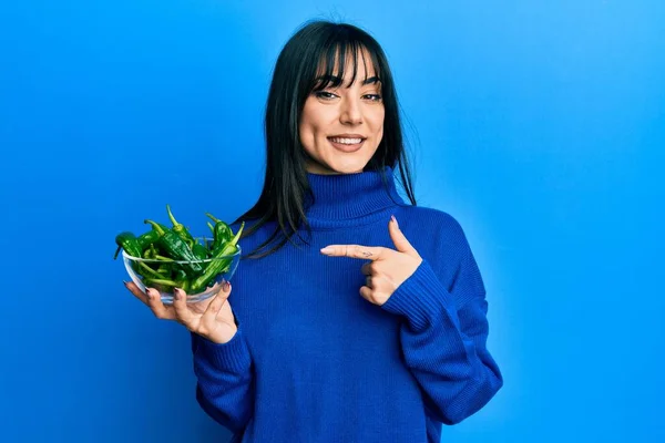 Young Brunette Woman Bangs Holding Bowl Green Peppers Smiling Happy — Stockfoto