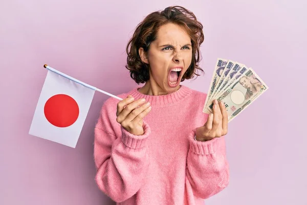 Mujer Morena Joven Sosteniendo Bandera Japón Billetes Yen Enojado Loco —  Fotos de Stock