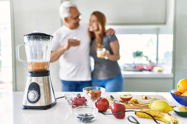 Pareja Hispana Mediana Edad Sonriendo Feliz Abrazando Vaso Batido Cocina —  Fotos de Stock