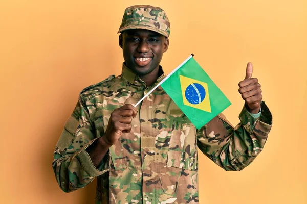 Joven Hombre Afroamericano Vistiendo Uniforme Del Ejército Sosteniendo Bandera Brasileña —  Fotos de Stock