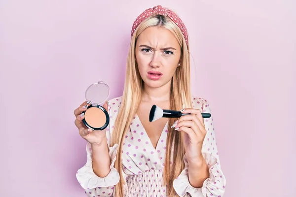 Young Blonde Girl Holding Makeup Bronzer Brush Shock Face Looking — Stock Photo, Image