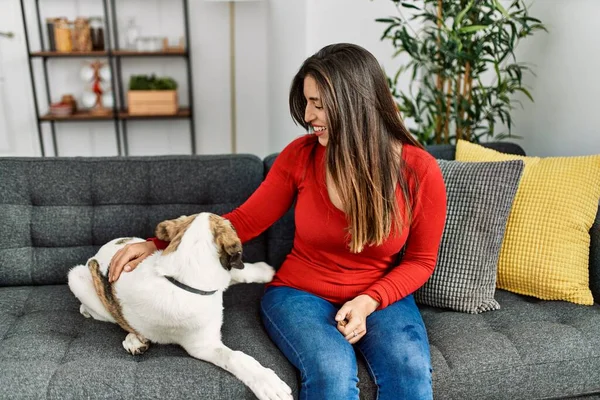 Mujer Joven Sonriendo Confiada Sentada Sofá Con Perro Casa —  Fotos de Stock