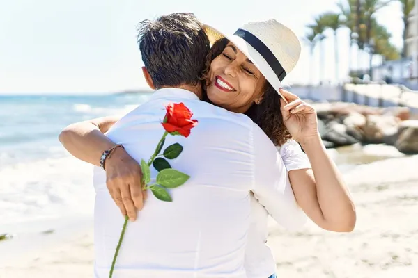 Middelbare Leeftijd Spaanse Paar Knuffelen Houden Bloem Het Strand — Stockfoto