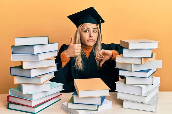 Junge Kaukasische Frau Abschlusszeremoniengewand Auf Dem Tisch Sitzend Daumen Hoch — Stockfoto