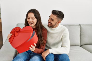 Genç İspanyol çift gülümsüyor. Sevgililer günü hediyesiyle mutlu bir sürpriz..