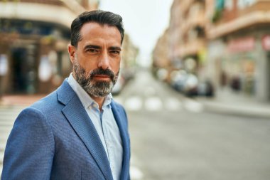 Şehirde duran rahat yüzlü orta yaşlı iş adamı..