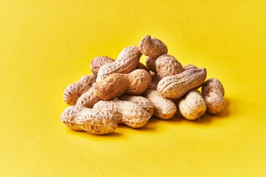  Sarı arka planda kabuklu bir avuç fıstık.