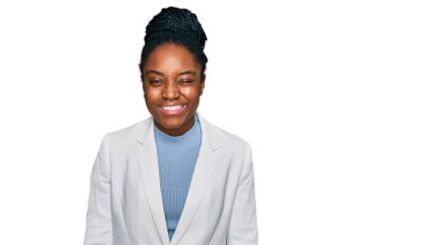 Genç Afro-Amerikan kadın iş kıyafetleri içinde kameraya seksi bir ifadeyle bakıyor, neşeli ve mutlu bir yüzle.. 