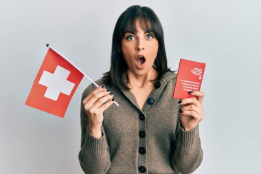 Elinde İsviçre bayrağı ve pasaportu olan genç İspanyol kadın şaşkınlık ve şaşkınlık dolu bir ifade, korku ve heyecan dolu bir yüz ile şoka uğradı.. 