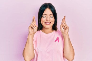 Gömleğine pembe kanser kurdelesi takmış genç İspanyol kadın umut ve gözleriyle gülümseyerek bana işaret ediyor. Şans ve batıl inançlar. 