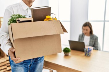 Orta yaşlı erkek ve kadın işçiler çalışanı kovuyor.