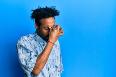 Sakallı, sıradan giyinmiş, burnu ve gözleri ovuşturup yorgun ve başı ağrıyan Afrikalı genç bir Amerikalı. Stres ve hüsran kavramı. 