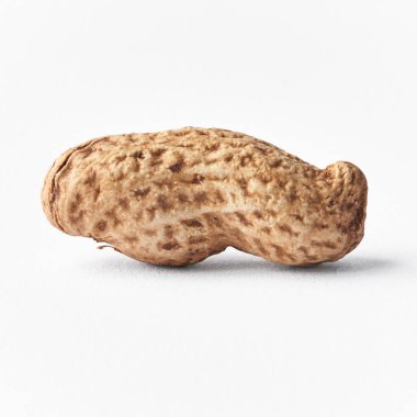  Beyaz arka planda kabuklu tek bir fıstık.