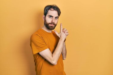 Sakallı, sıradan sarı tişörtlü, el hareketleriyle sembolik silah tutan, cinayet silahlarıyla oynayan, sinirli yüzlü, beyaz bir adam. 