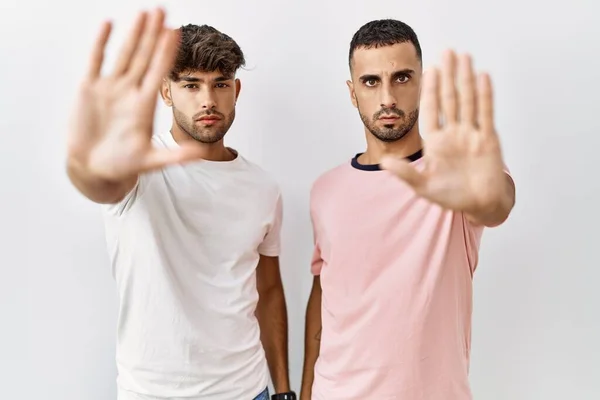 Young Gay Couple Standing Isolated Background Doing Stop Sing Palm — Stock Fotó