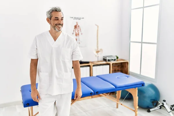 Middle Age Hispanic Therapist Man Working Pain Recovery Clinic Looking — Stockfoto