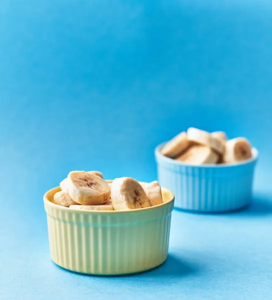 Schaal Van Schijfjes Bananen Een Blauwe Achtergrond — Stockfoto