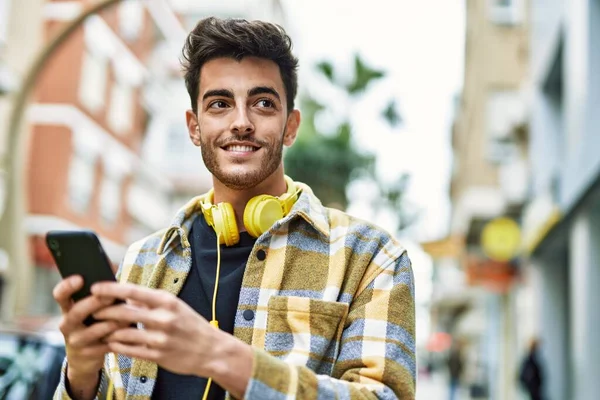 Przystojny Latynos Uśmiecha Się Szczęśliwy Pewny Siebie Mieście Pomocą Smartfona — Zdjęcie stockowe