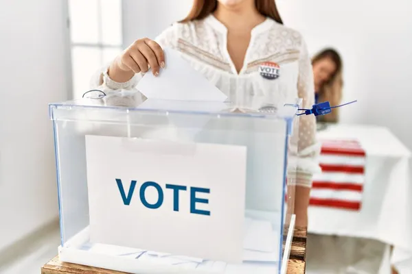 American voter woman putting party vote in ballot at electoral college.