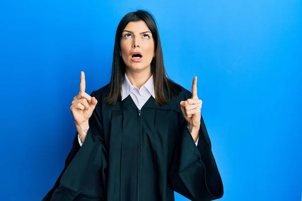 Young Hispanic Woman Wearing Judge Uniform Amazed Surprised Looking Pointing — Photo