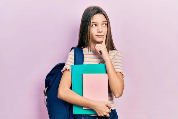 Chica Morena Joven Sosteniendo Mochila Estudiantil Libros Cara Seria Pensando —  Fotos de Stock