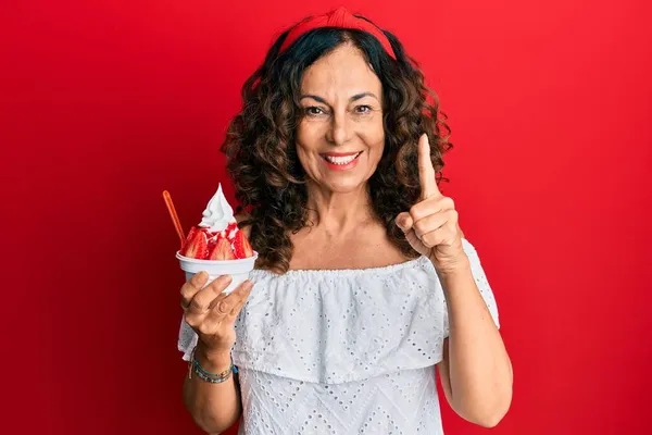 Middelbare Spaanse Vrouw Die Aardbeienijs Eet Glimlachend Met Een Idee — Stockfoto