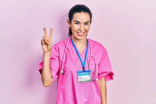 Doktor Üniforması Giyen Genç Esmer Kadın Steteskop Iki Numarayı Gösterip — Stok fotoğraf