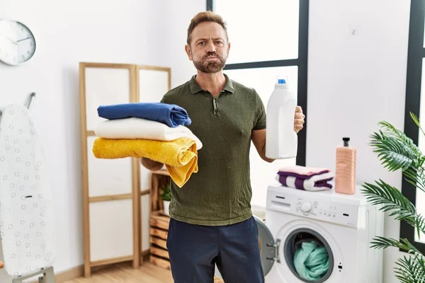 Middle Age Man Holding Clean Laundry Detergent Bottle Puffing Cheeks — Stockfoto