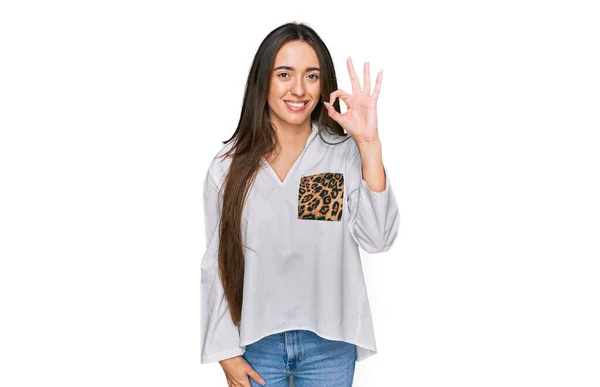 手や指でOkのサインをしながら積極的に笑顔カジュアルな服を着て若いヒスパニック系の女の子 成功した表現 — ストック写真