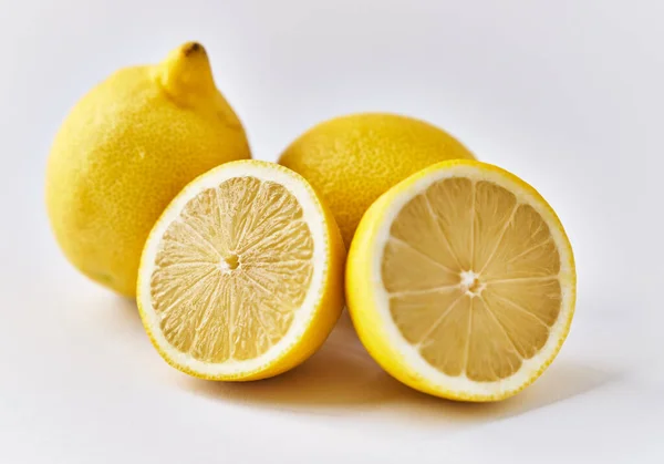 白い背景にレモンの実と半分が2つ — ストック写真