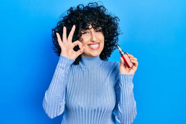 Young Middle East Woman Holding Electronic Cigarette Doing Sign Fingers — Stockfoto