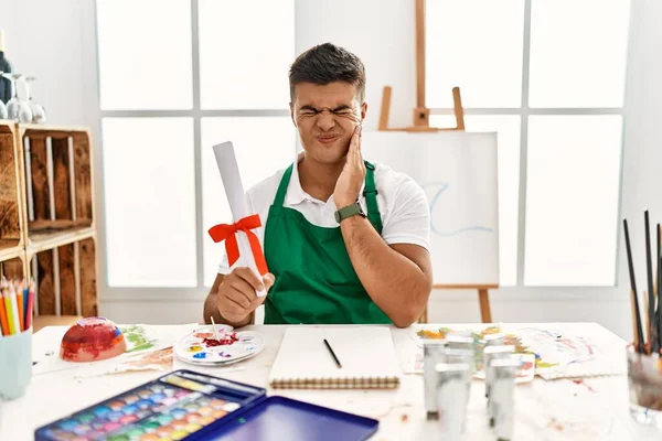 Young Hispanic Man Art Studio Holding Degree Touching Mouth Hand — Stock fotografie