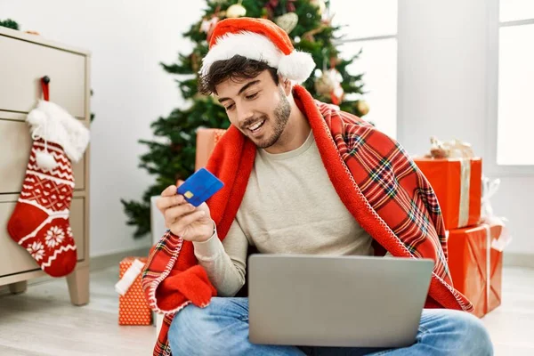 Jonge Spaanse Man Draagt Kerstmuts Met Laptop Creditcard Thuis — Stockfoto