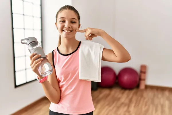 Ung Brunette Teenager Iført Sportstøj Holder Vandflaske Smilende Munter Visning - Stock-foto