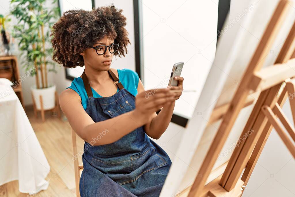 Young african american woman making picture by smartphone drawing at art studio