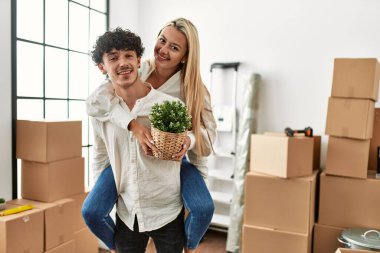 Genç adam yeni evinde kadını sırtında tutuyor..