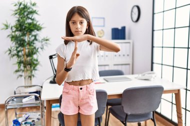 Genç İspanyol kız pediatri kliniğinde duruyor. Elleriyle jest yapıyor. Hayal kırıklığına uğramış ve ciddi bir yüz ifadesi var. 