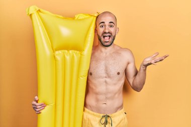 Mayolu ve elinde yaz şiltesi tutan genç kel adam zaferi kutluyor. Gülümsüyor ve kazanan el kaldırıyor. 