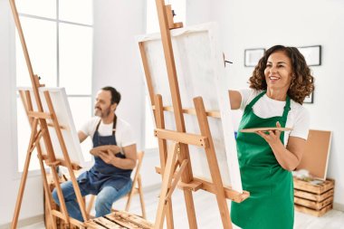 Resim stüdyosunda gülümseyen iki orta yaşlı öğrenci..